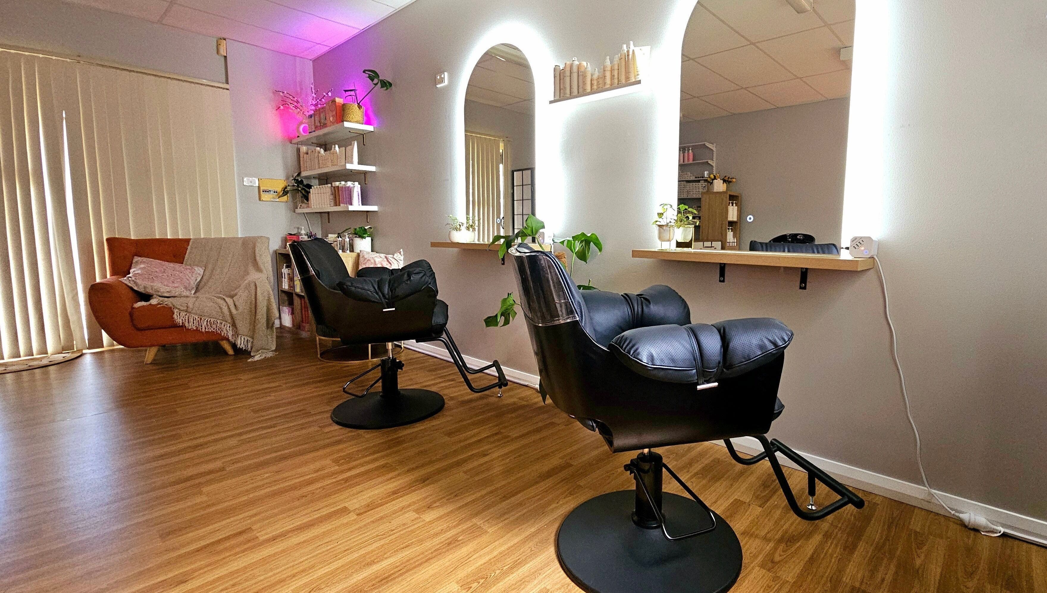 Chic interior of Hair By Hayley, Milpara, Western Australia, AU, featuring sleek styling chairs and cozy seating.