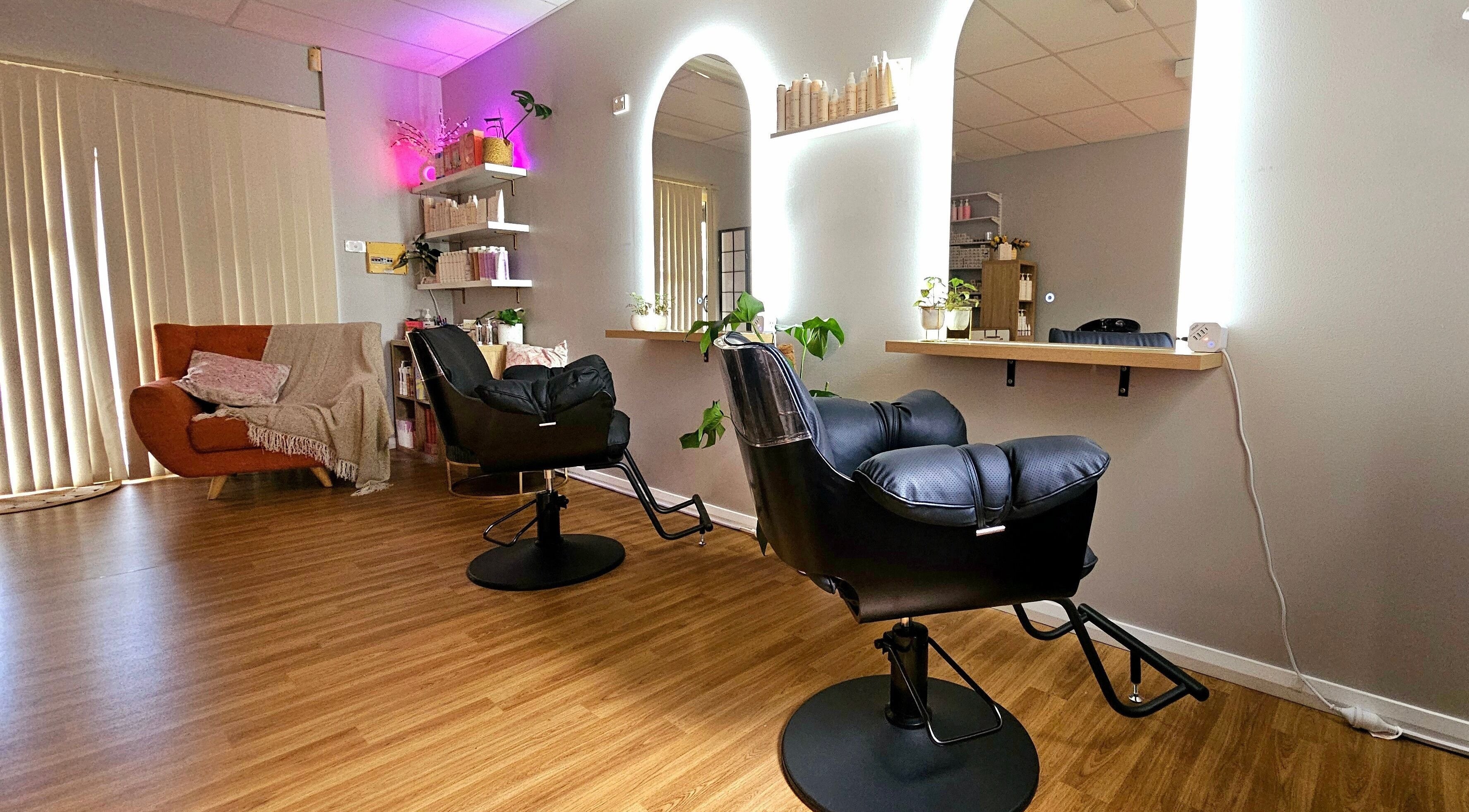 Chic interior of Hair By Hayley, Milpara, Western Australia, AU, featuring sleek styling chairs and cozy seating.