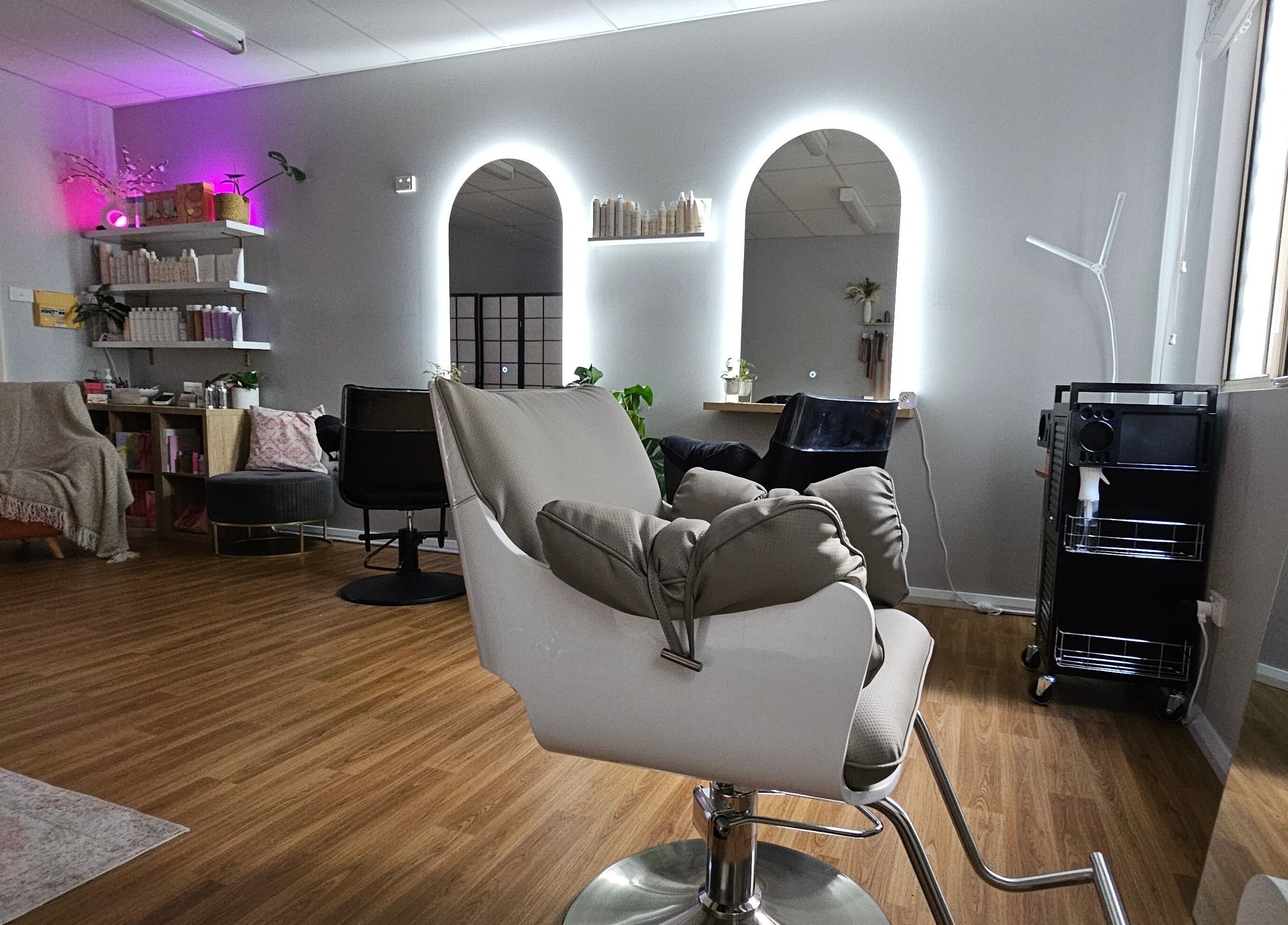 Modern salon interior at Hair By Hayley, Milpara, Western Australia, AU with stylish chairs and illuminated mirrors.
