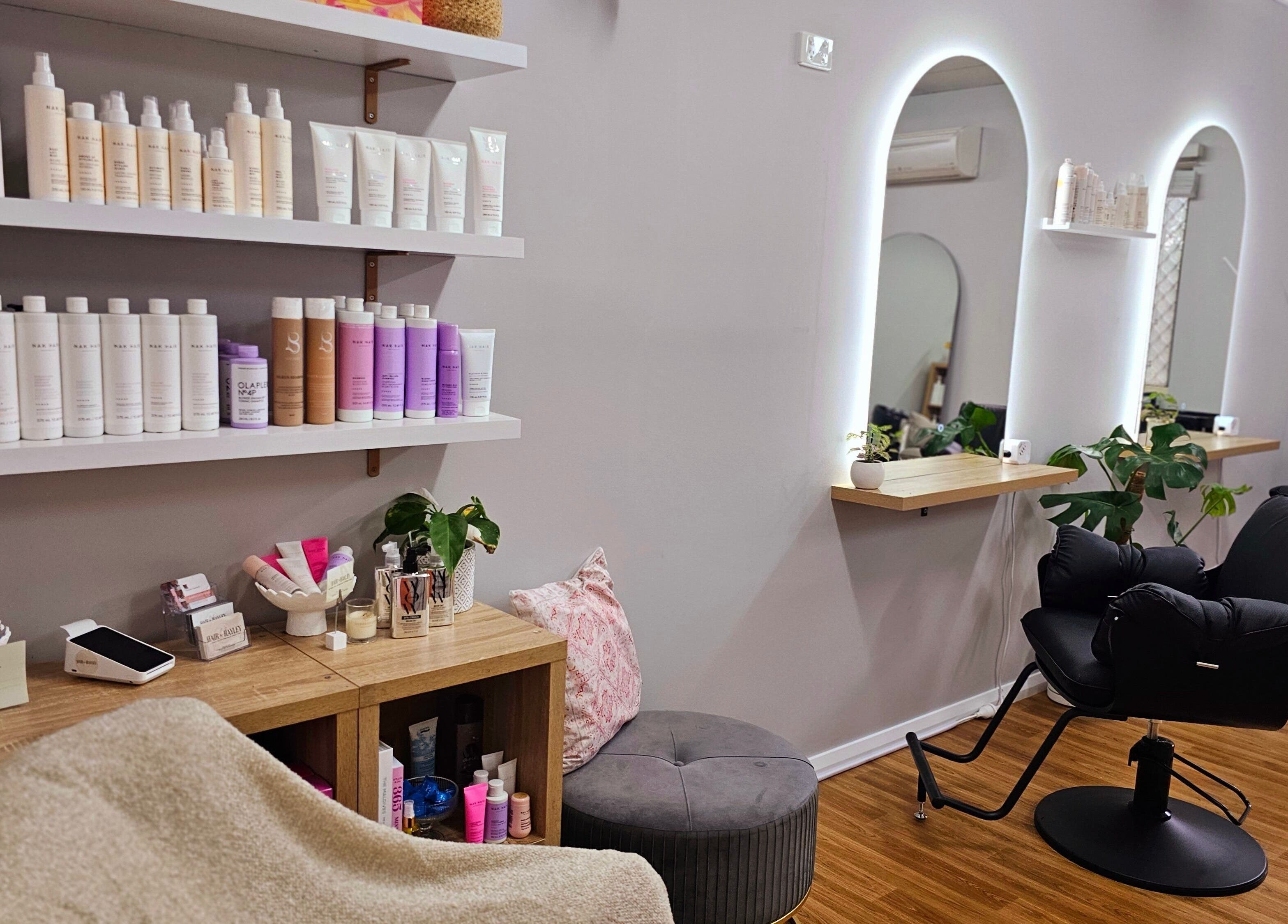 Cozy salon interior at Hair By Hayley in Milpara, Western Australia, AU, showcasing products and styling areas.