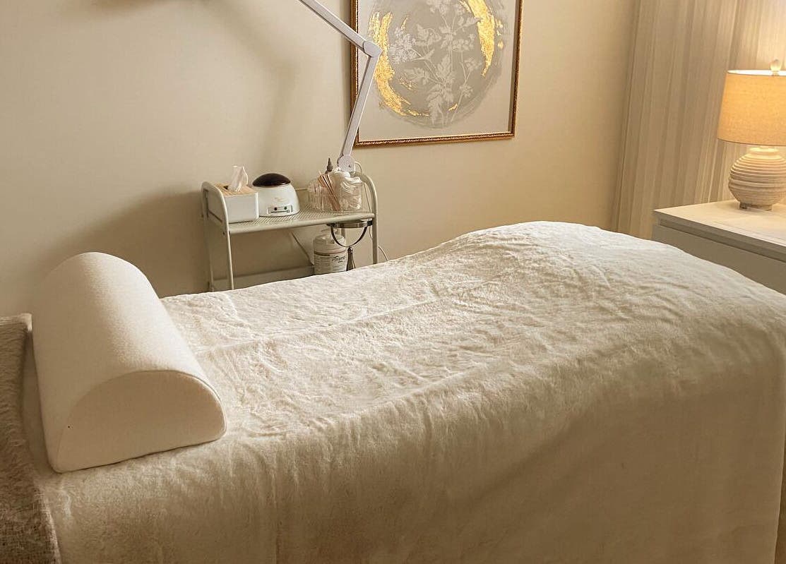 Relaxing treatment room at The Natural Brow, Edmonton, Alberta, CA with cozy bedding and warm lighting.