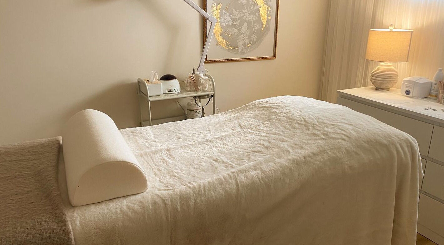 Relaxing treatment room at The Natural Brow, Edmonton, Alberta, CA with cozy bedding and warm lighting.