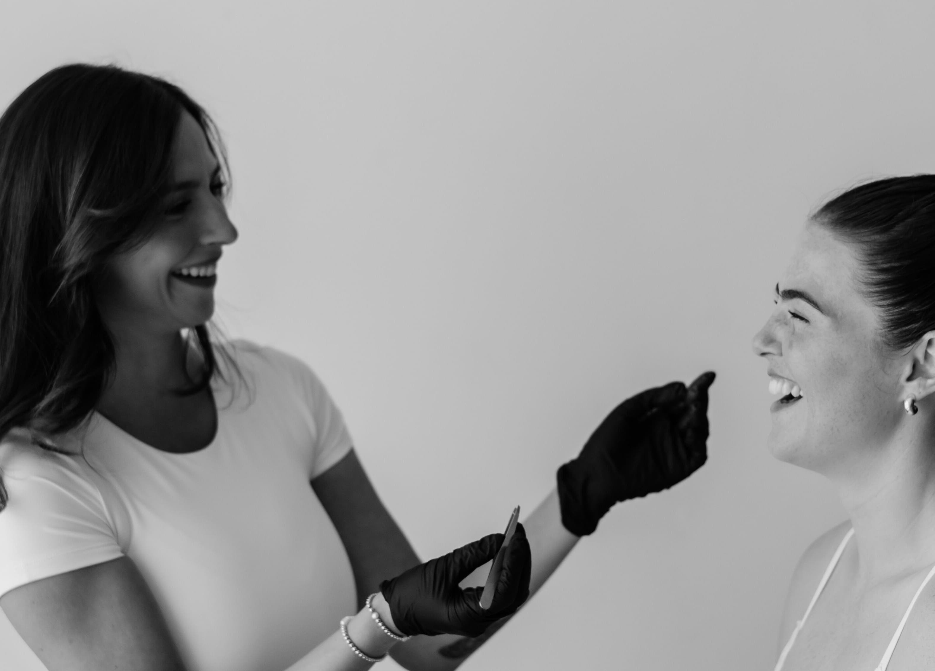 Beauty treatment at The Natural Brow in Edmonton, Alberta, CA. Smiling client and professional interaction.