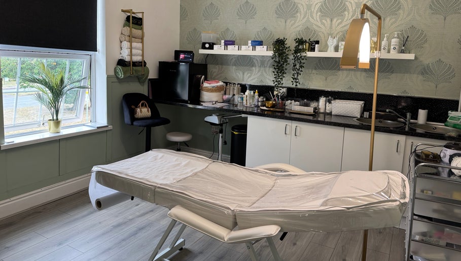 Cozy treatment room at Saving Face Aesthetics & Beauty, Warrington, England, GB, featuring a massage table and decor.
