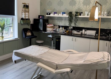 Cozy treatment room at Saving Face Aesthetics & Beauty, Warrington, England, GB, featuring a massage table and decor.