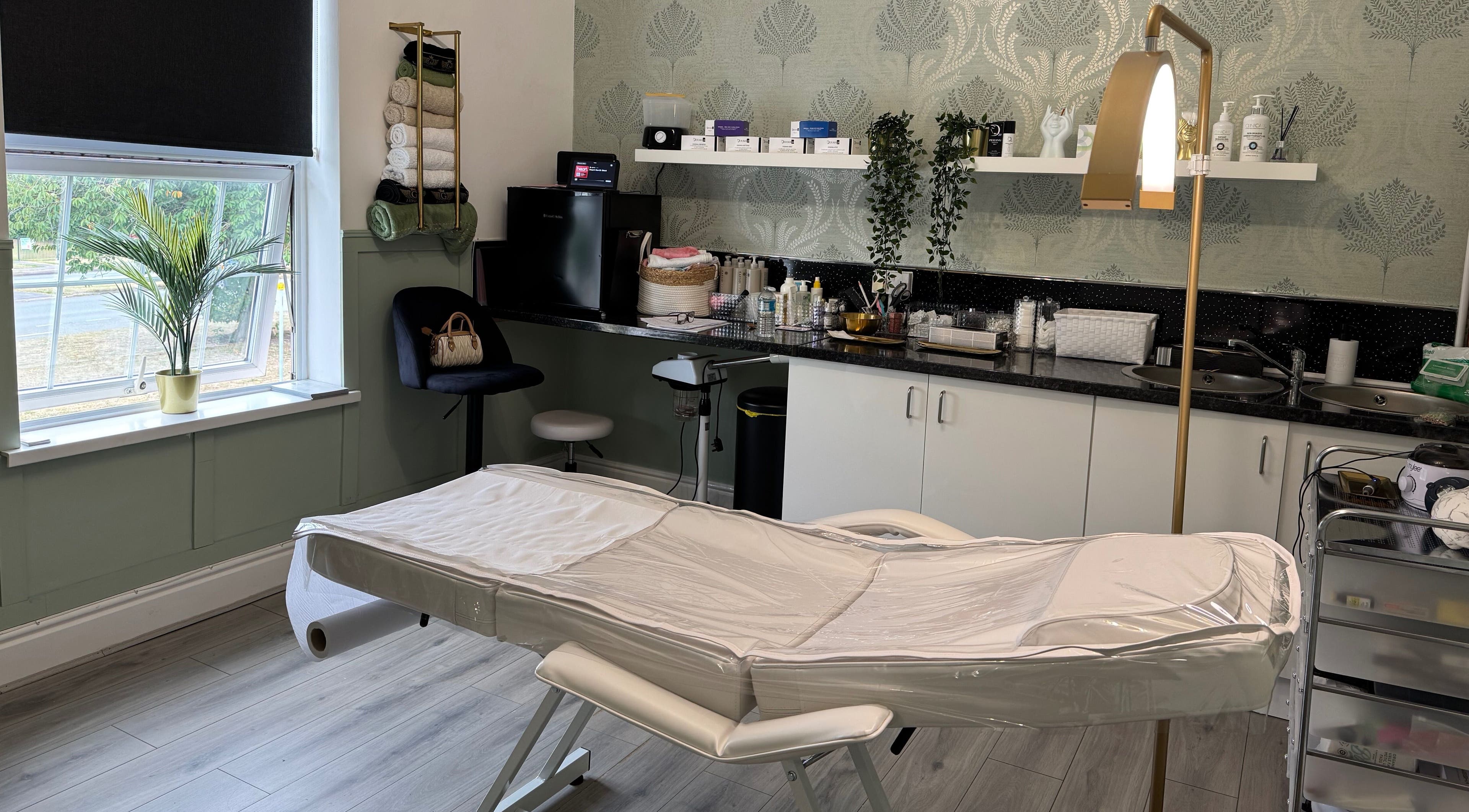 Cozy treatment room at Saving Face Aesthetics & Beauty, Warrington, England, GB, featuring a massage table and decor.