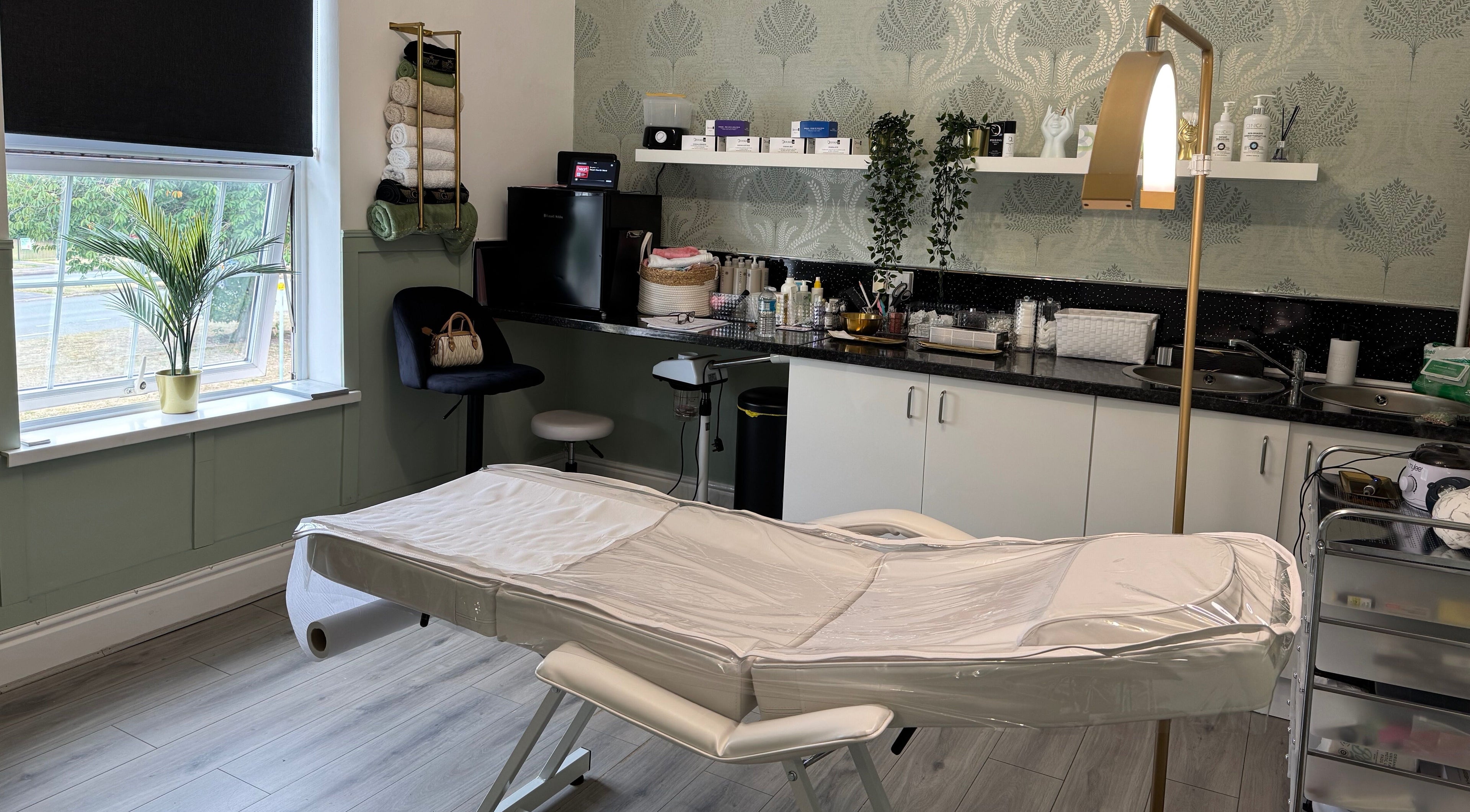 Cozy treatment room at Saving Face Aesthetics & Beauty, Warrington, England, GB, featuring a massage table and decor.
