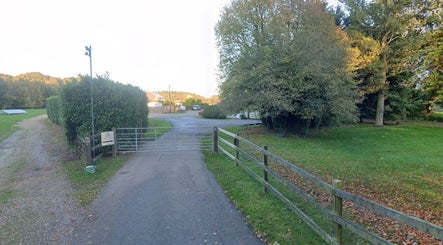 Entrance gate to Enchanted By Em, a serene beauty venue in Narborough, England, GB, surrounded by lush greenery.