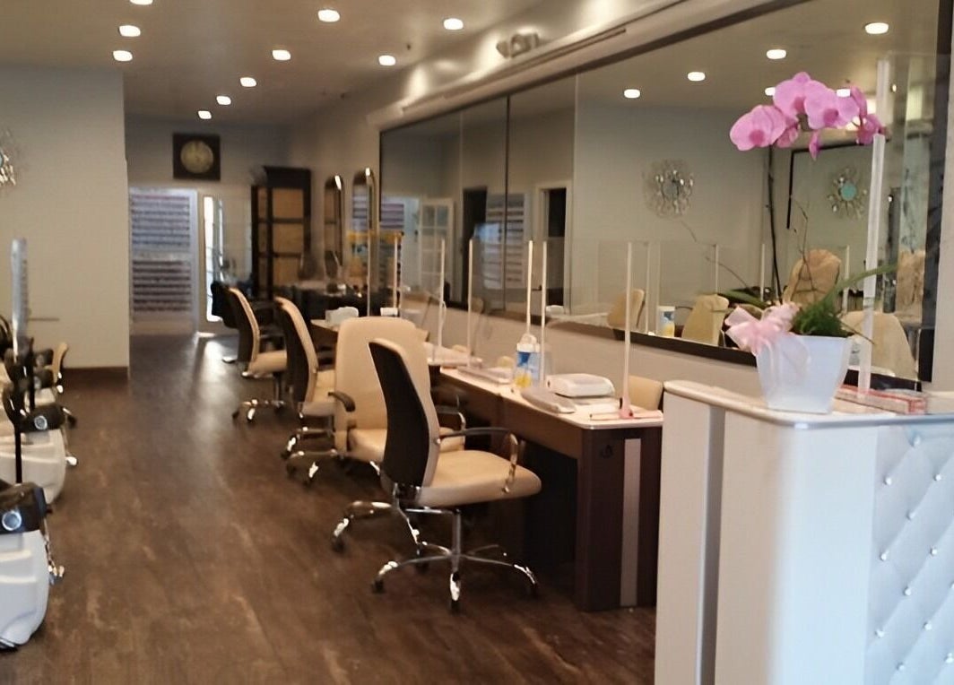 Interior of T Nail Salon in Santa Clara, California, US with elegant chairs and pink orchids.