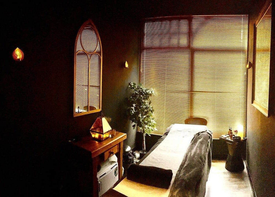 A serene massage room at Spa & Skin Lounge in Hastings, England, GB with warm lighting and cozy decor.