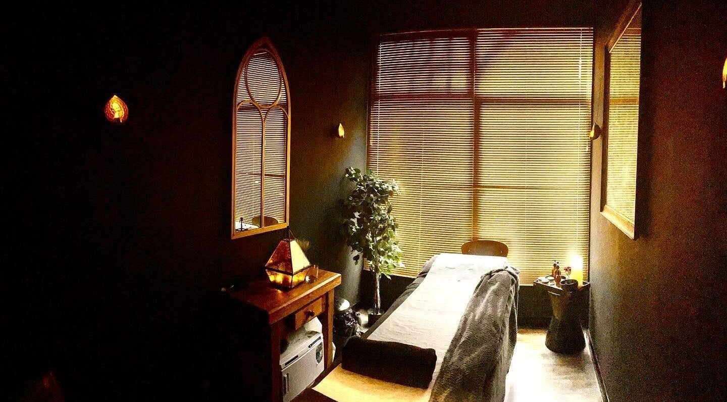 A serene massage room at Spa & Skin Lounge in Hastings, England, GB with warm lighting and cozy decor.