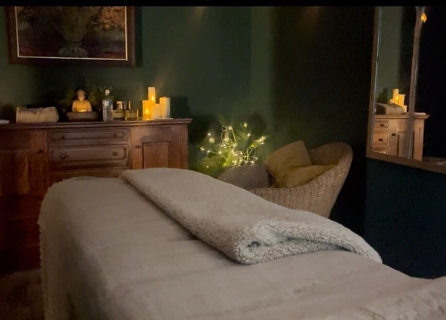 Cozy spa room at Spa & Skin Lounge in Hastings, England, GB featuring a massage table and warm lighting.