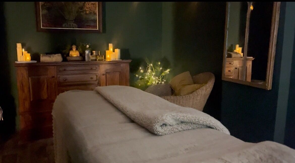 Cozy spa room at Spa & Skin Lounge in Hastings, England, GB featuring a massage table and warm lighting.