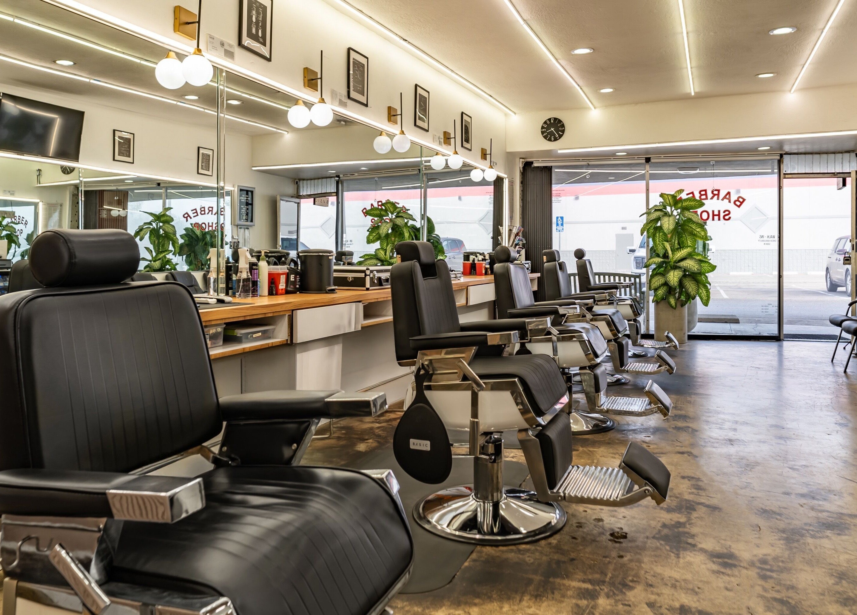Interior of Basic Barber in Costa Mesa, California, US, featuring sleek black chairs and modern decor.