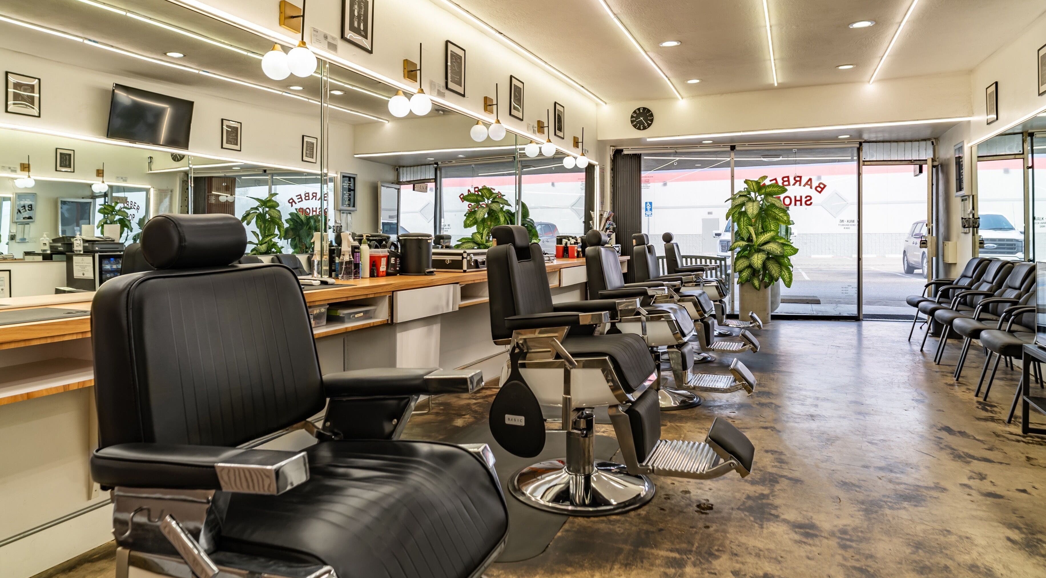 Interior of Basic Barber in Costa Mesa, California, US, featuring sleek black chairs and modern decor.