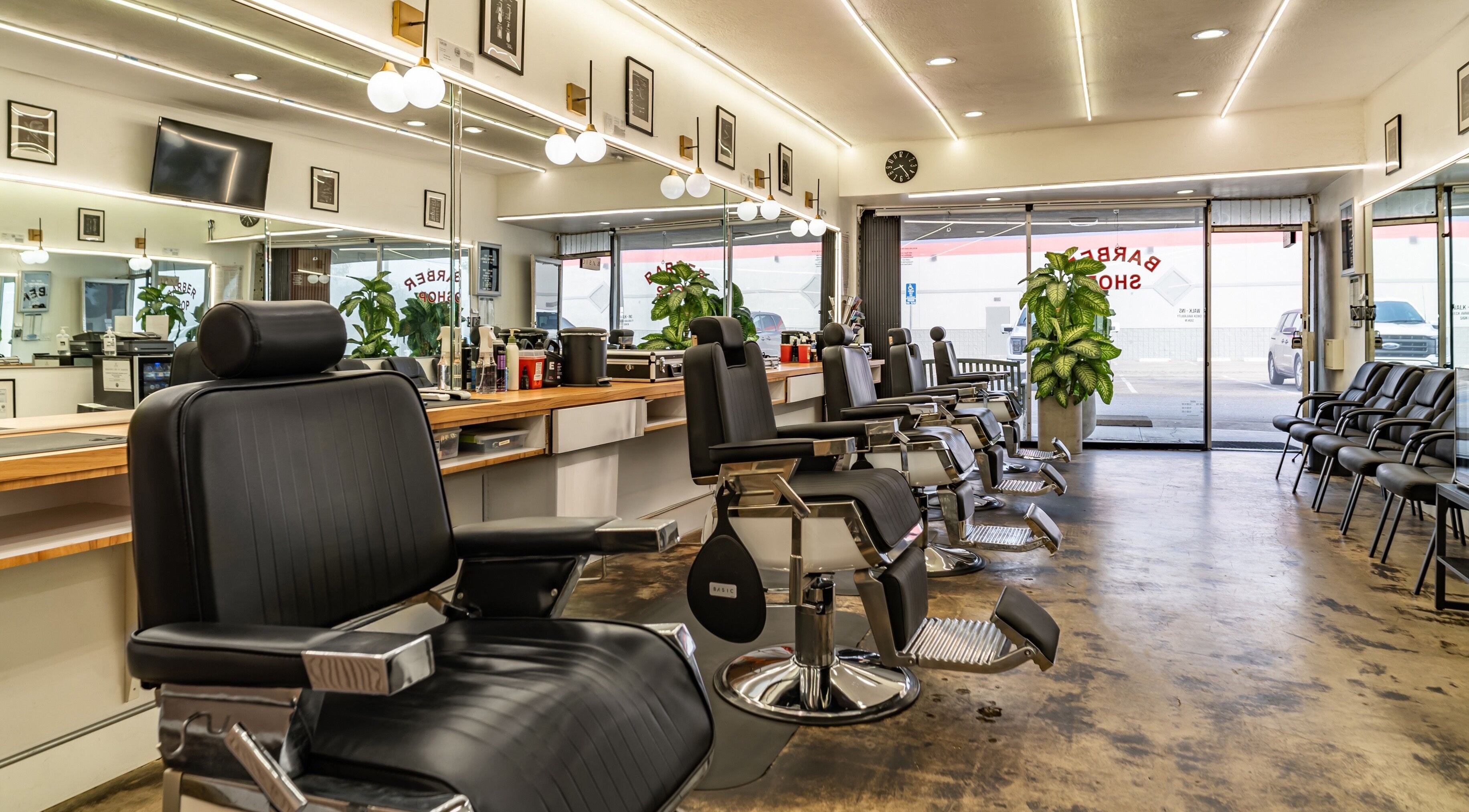 Interior of Basic Barber in Costa Mesa, California, US, featuring sleek black chairs and modern decor.
