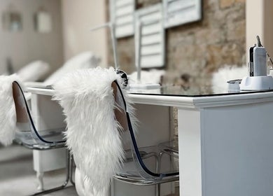 A chic nail salon setup at Nails by Amelia, Baildon, England, GB with white fur chairs and modern decor.