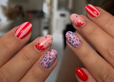 Creative nail art at Nails by Amelia, Baildon, England, GB with vibrant red stripes and floral designs.