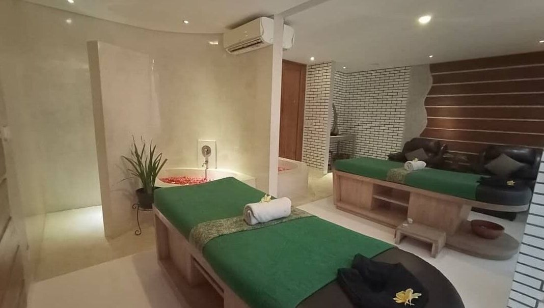 Luxurious treatment room at LLuvia Spa Bali, Bali, ID, featuring plush massage tables and elegant decor.