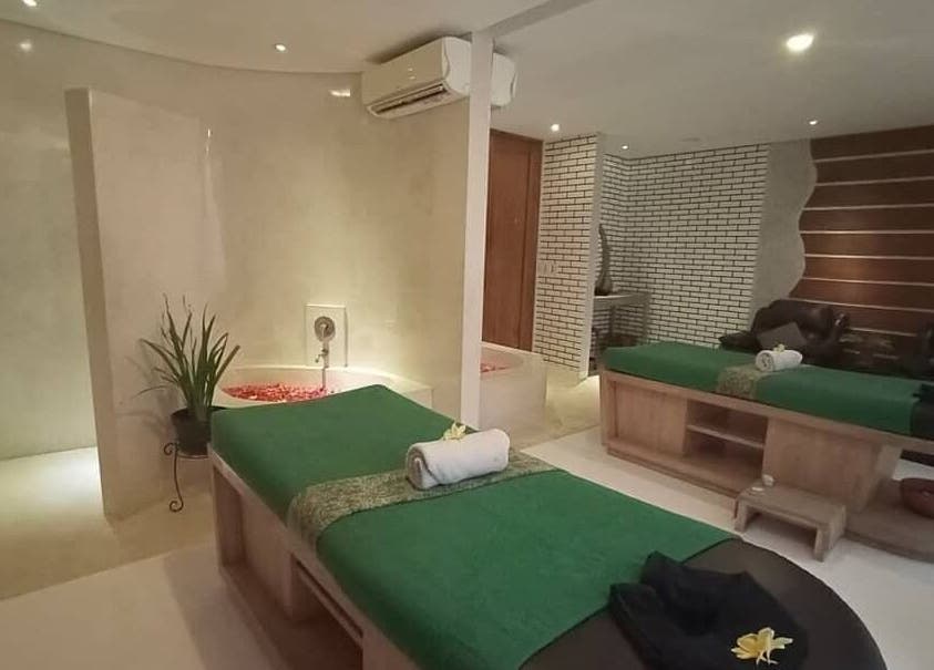 Luxurious treatment room at LLuvia Spa Bali, Bali, ID, featuring plush massage tables and elegant decor.