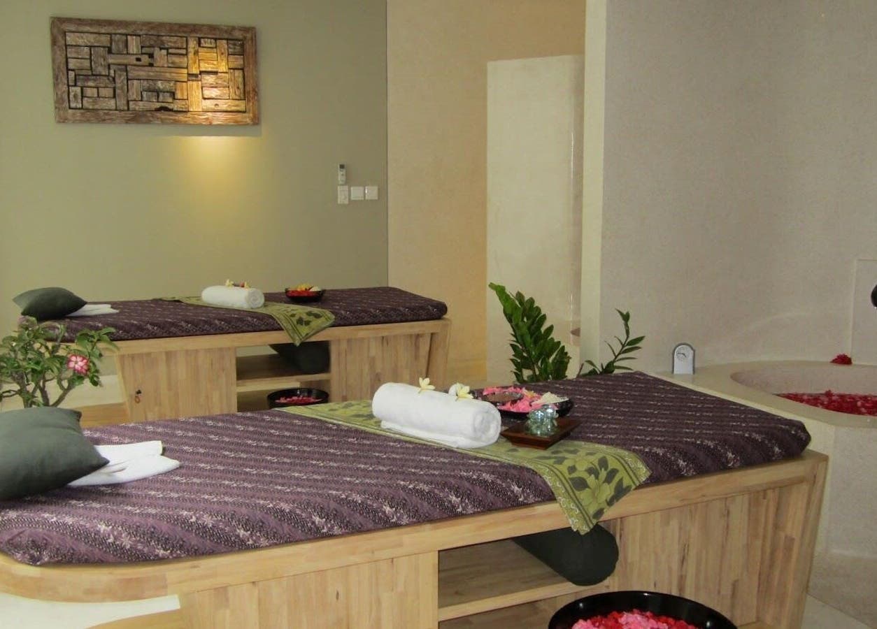 Relaxing spa room at LLuvia Spa Bali with two massage tables and soft lighting, Bali, Bali, ID.