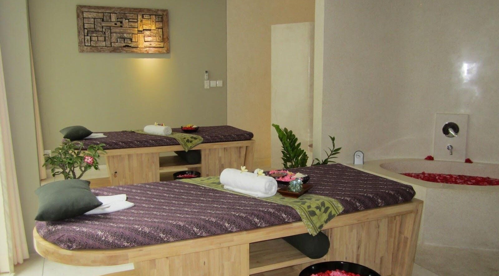 Relaxing spa room at LLuvia Spa Bali with two massage tables and soft lighting, Bali, Bali, ID.