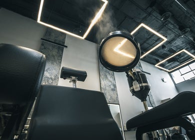 Modern barber chair under square lights at The Protocol Barbershop, Riyadh, Riyadh Province, SA.