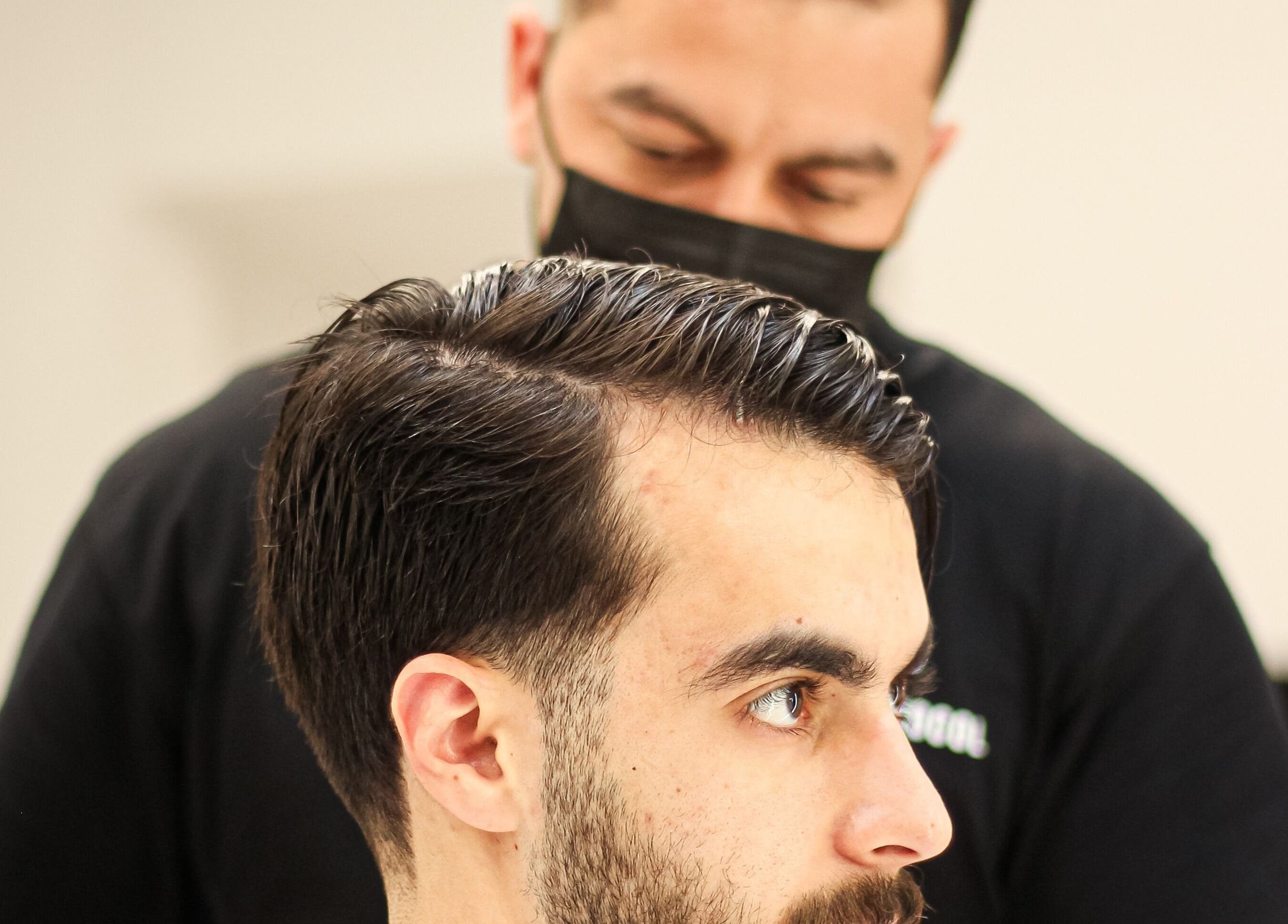 Barber crafting a stylish haircut at The Protocol Barbershop, Riyadh, Riyadh Province, SA.