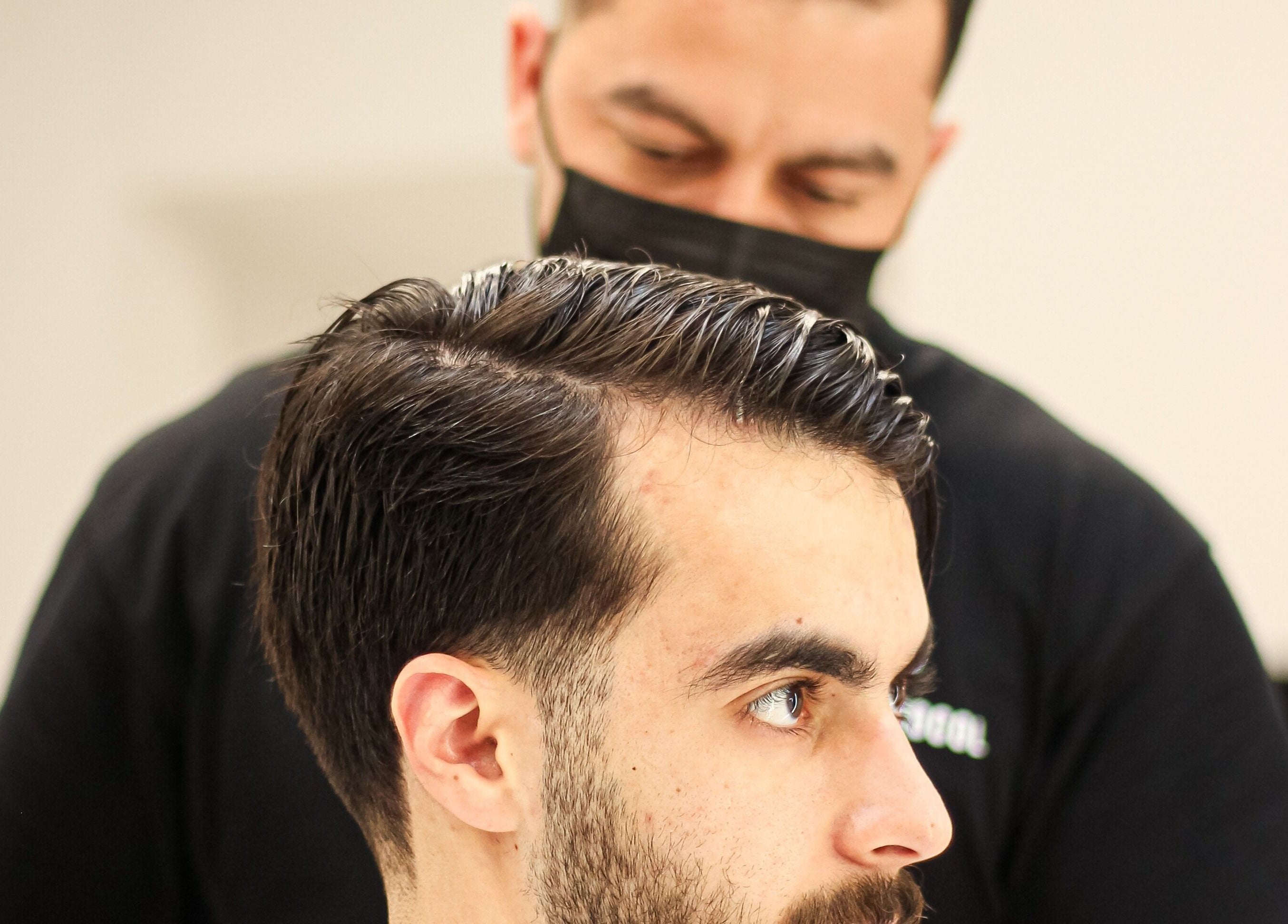 Barber crafting a stylish haircut at The Protocol Barbershop, Riyadh, Riyadh Province, SA.