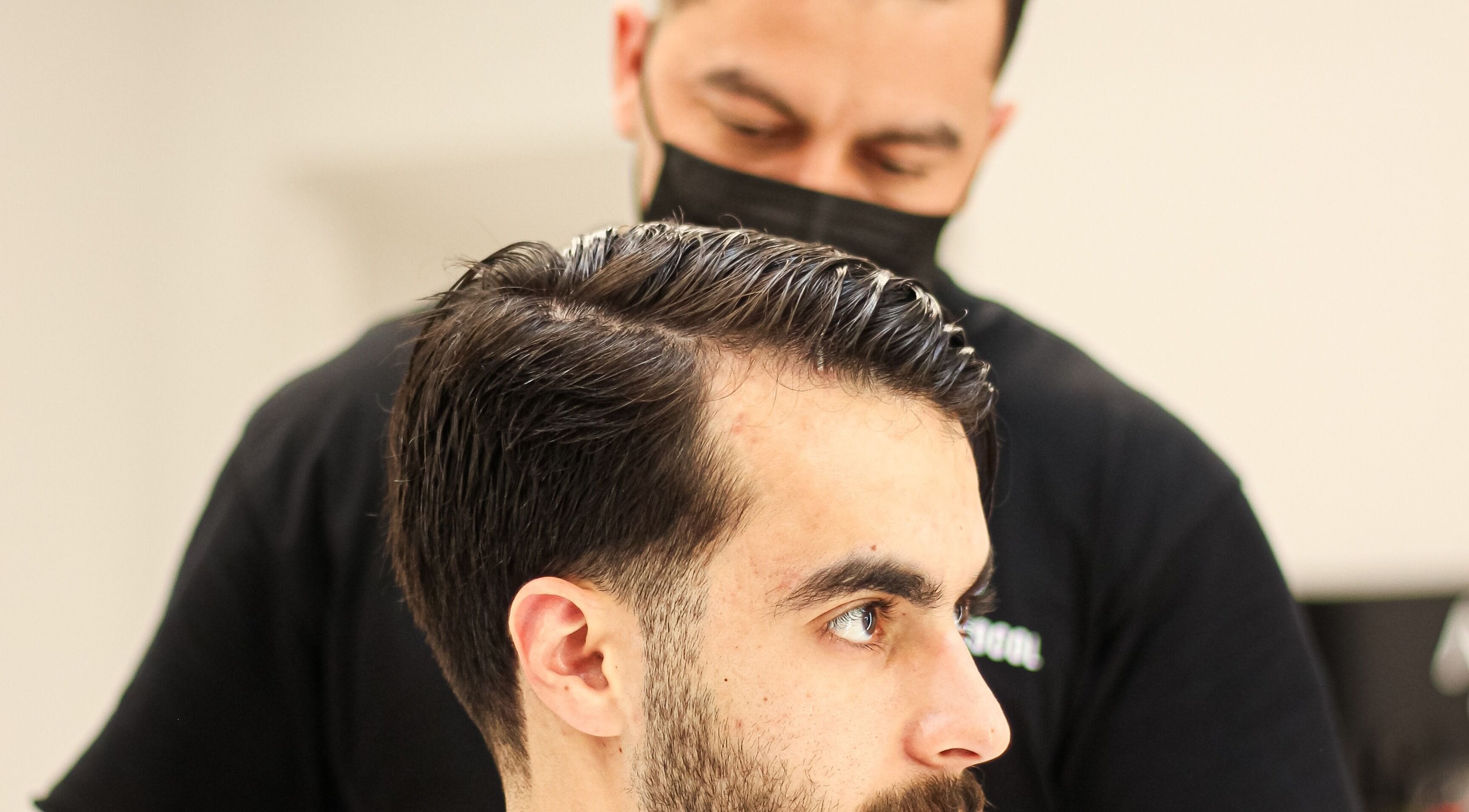 Barber crafting a stylish haircut at The Protocol Barbershop, Riyadh, Riyadh Province, SA.