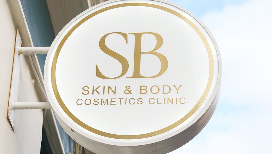 Exterior sign of SB Cosmetics Clinic, Glasgow, Scotland, GB, featuring gold lettering on a round design.