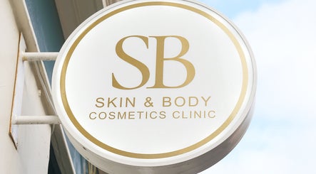 Exterior sign of SB Cosmetics Clinic, Glasgow, Scotland, GB, featuring gold lettering on a round design.