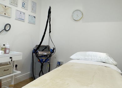 Calm treatment room at SB Cosmetics Clinic, Glasgow, Scotland, GB, showcasing a massage bed and beauty equipment.