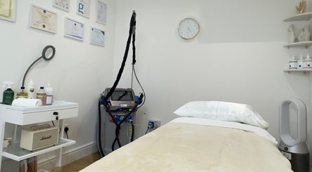 Calm treatment room at SB Cosmetics Clinic, Glasgow, Scotland, GB, showcasing a massage bed and beauty equipment.