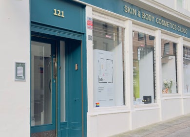 Entrance of SB Cosmetics Clinic on a street in Glasgow, Scotland, GB, showcasing elegant signage and window displays.