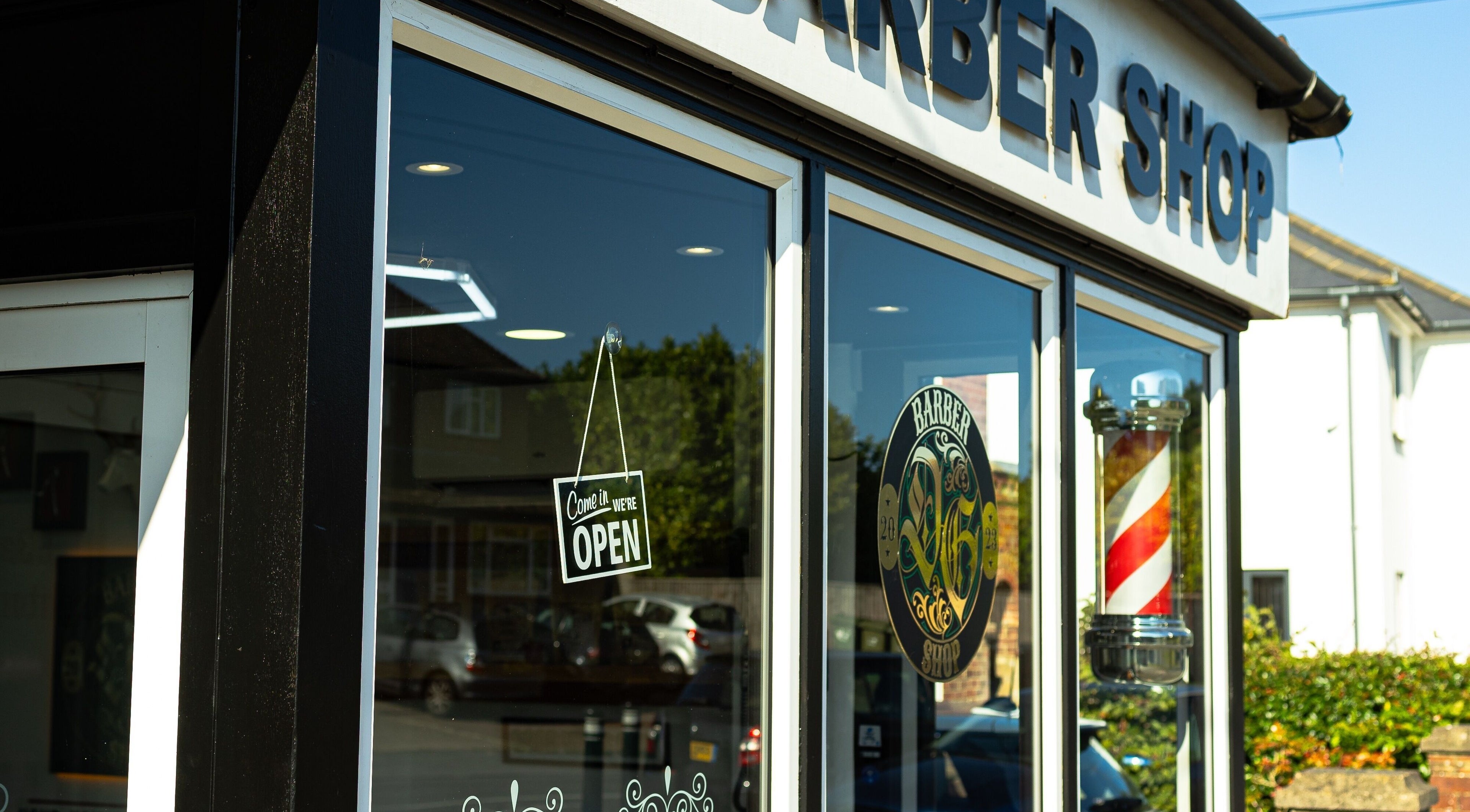DG barbershop exterior with open sign, Guildford, England, GB.