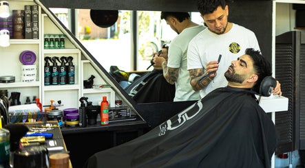Barber expertly grooming client at DG Barbershop in Guildford, England, GB.