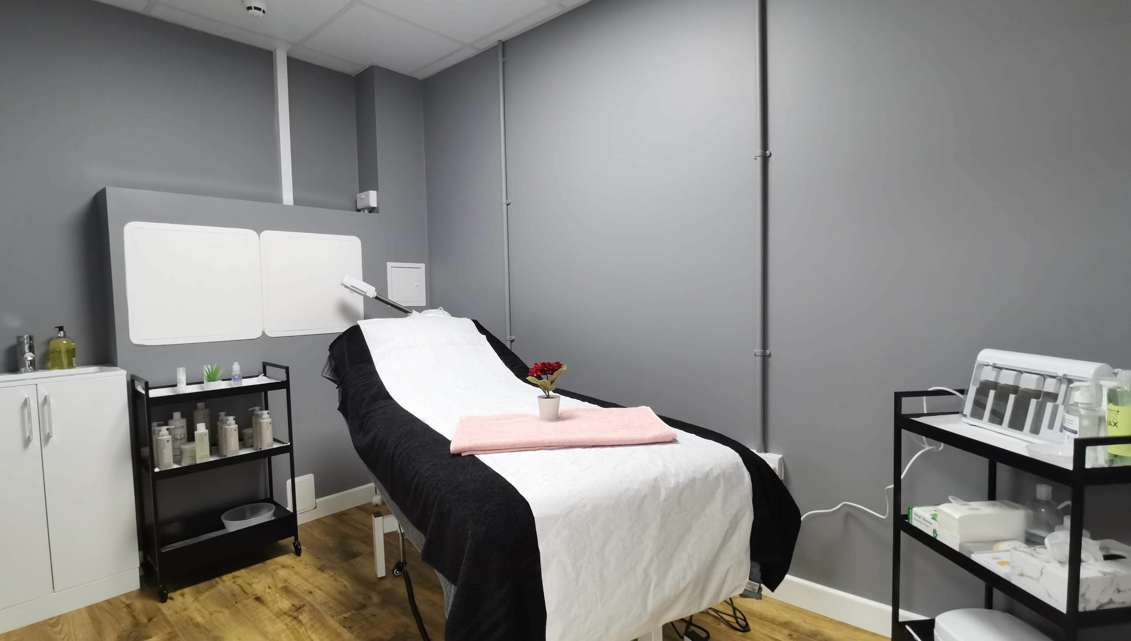 Treatment room at Glowfinity - Wokingham with a massage bed and skincare products. Location: Wokingham, GB.