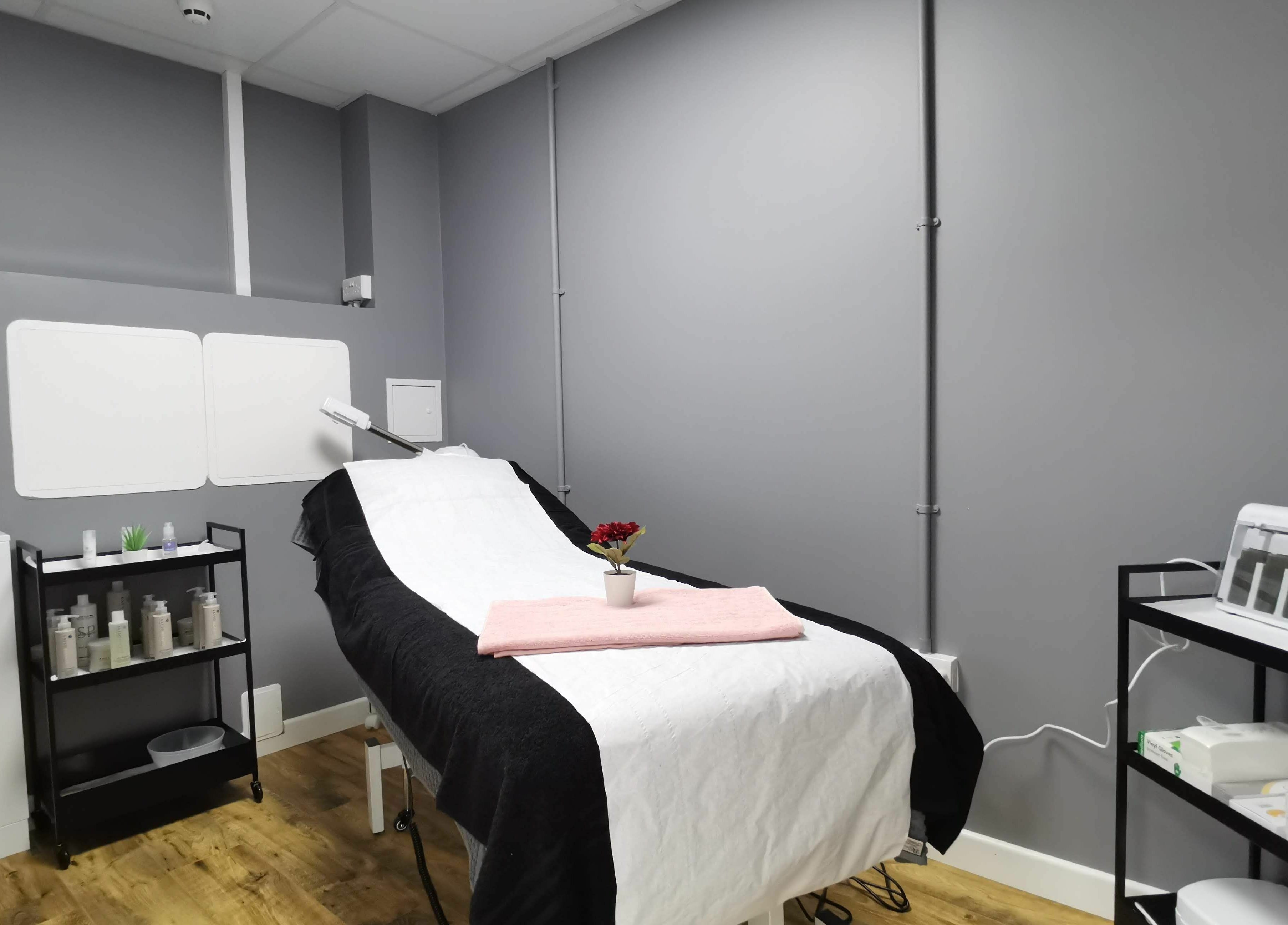 Treatment room at Glowfinity - Wokingham with a massage bed and skincare products. Location: Wokingham, GB.