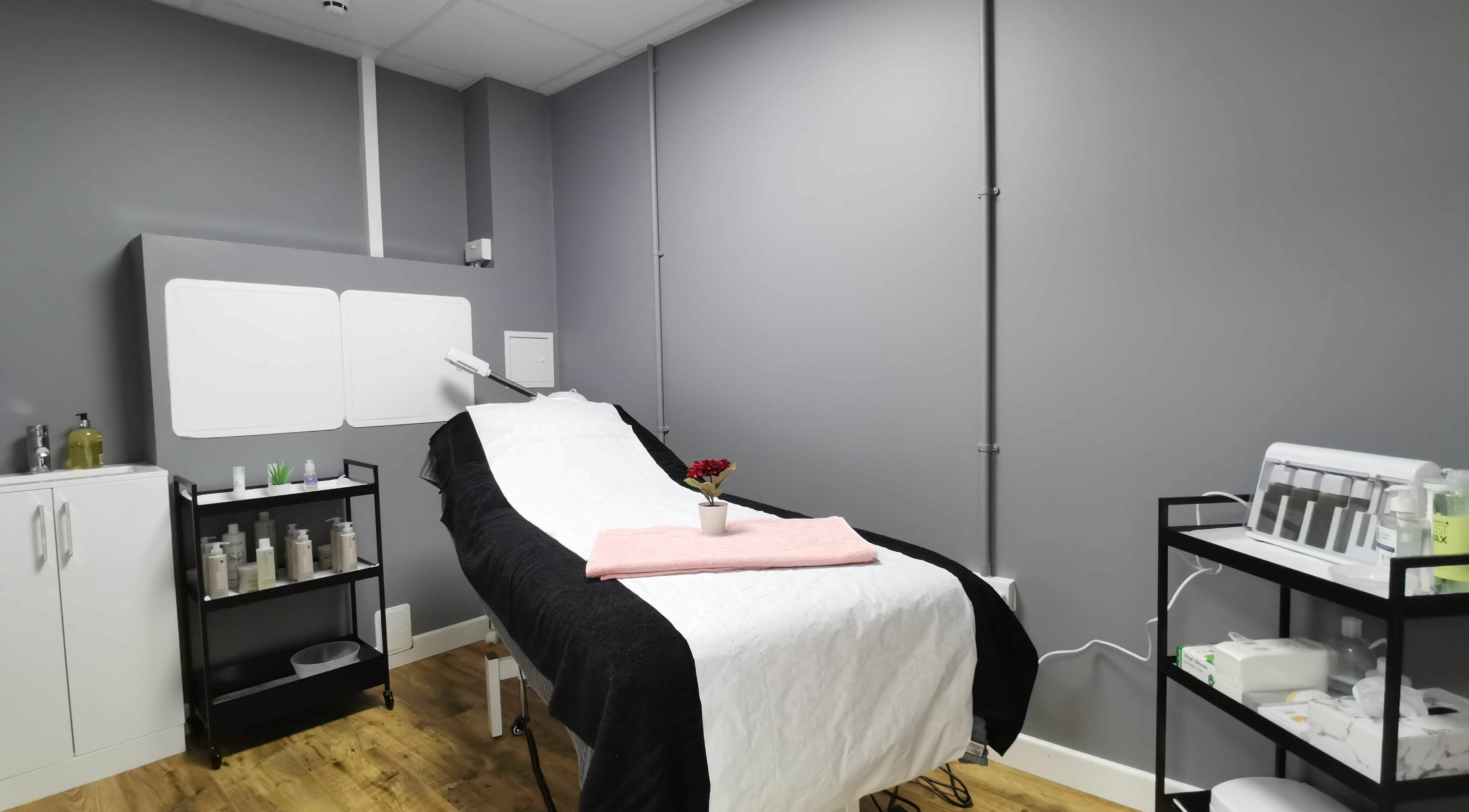 Treatment room at Glowfinity - Wokingham with a massage bed and skincare products. Location: Wokingham, GB.