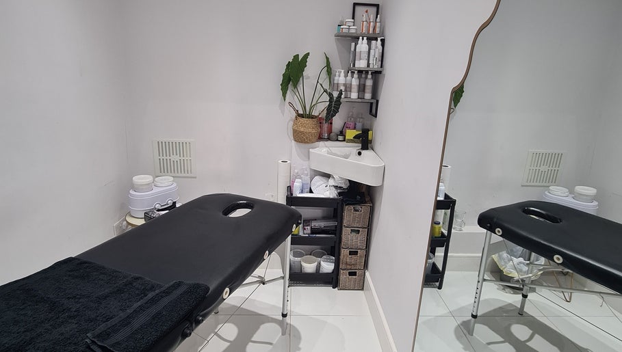Tranquil treatment room at Waxing Crescent, Willington, England, GB, with cozy massage bed and skincare products.