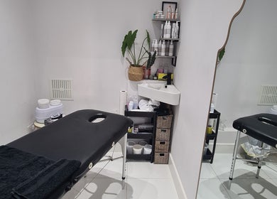 Tranquil treatment room at Waxing Crescent, Willington, England, GB, with cozy massage bed and skincare products.