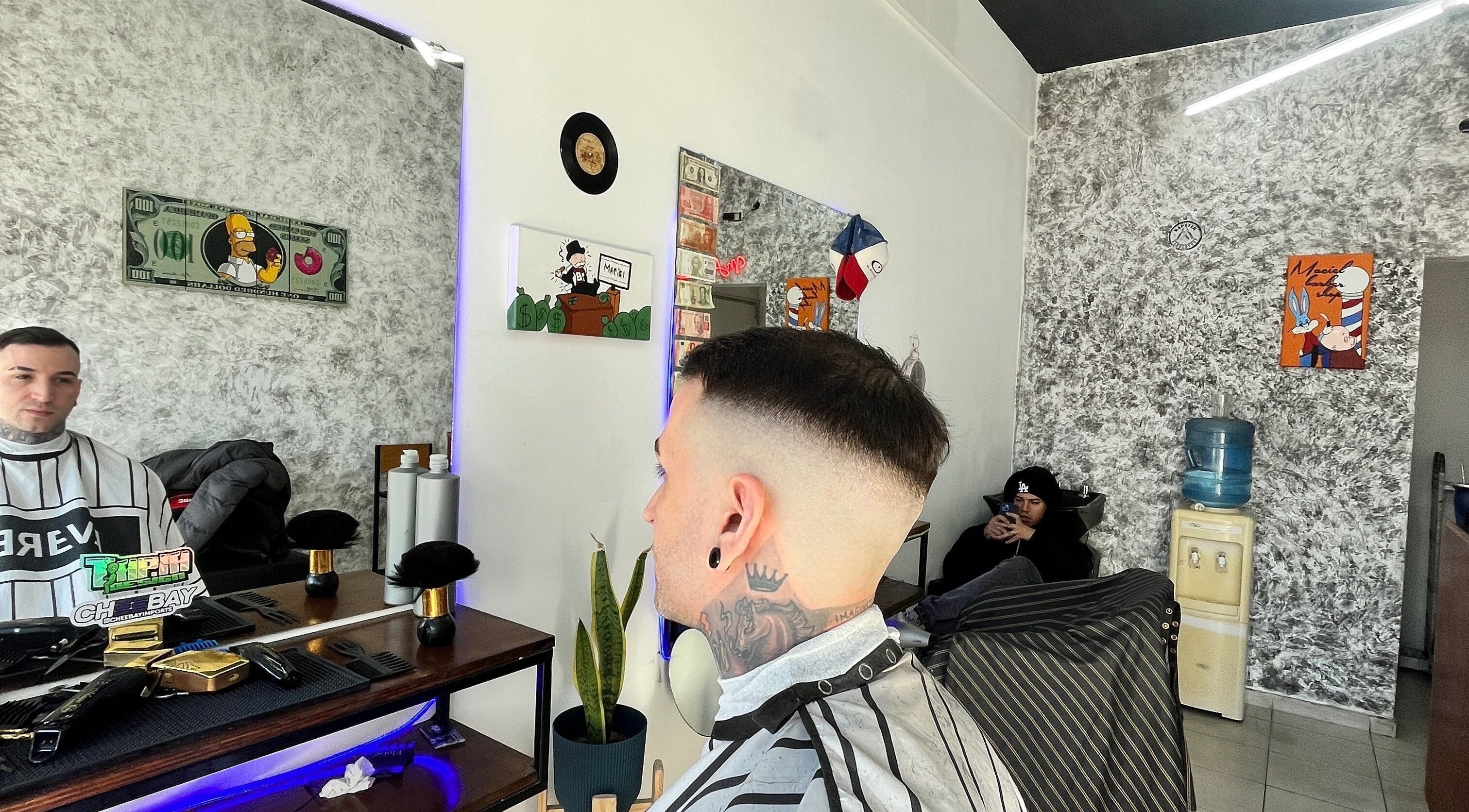 Interior de Maciel Barberia en Bernal Oeste, Provincia De Buenos Aires, AR, mostrando cortes modernos y decoración artística.