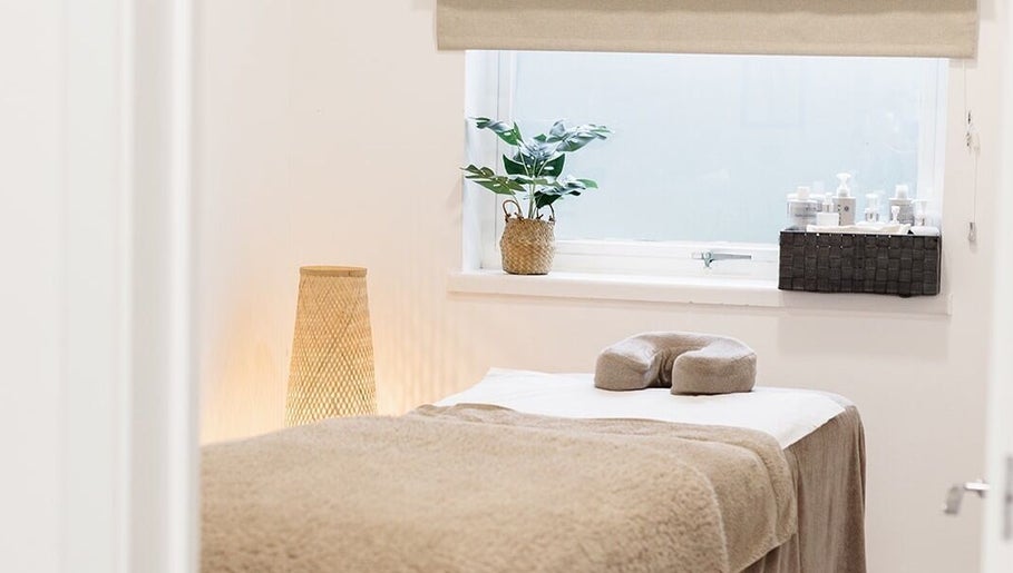 Serene spa room at Laura Bell Salon, Falmouth, England, GB, featuring a cozy massage bed and soothing decor.