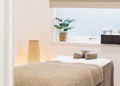 Serene spa room at Laura Bell Salon, Falmouth, England, GB, featuring a cozy massage bed and soothing decor.