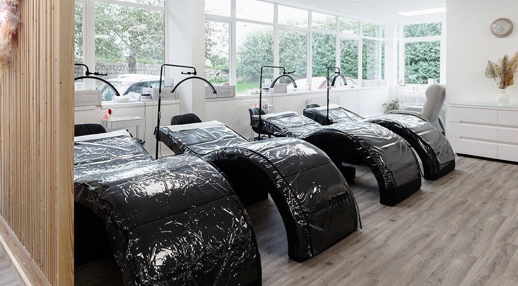 Relaxing treatment area at Laura Bell Salon, Falmouth, England, GB, with modern reclining chairs.