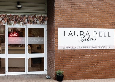 Entrance of Laura Bell Salon, Falmouth, England, showcasing elegant decor and welcoming sign.