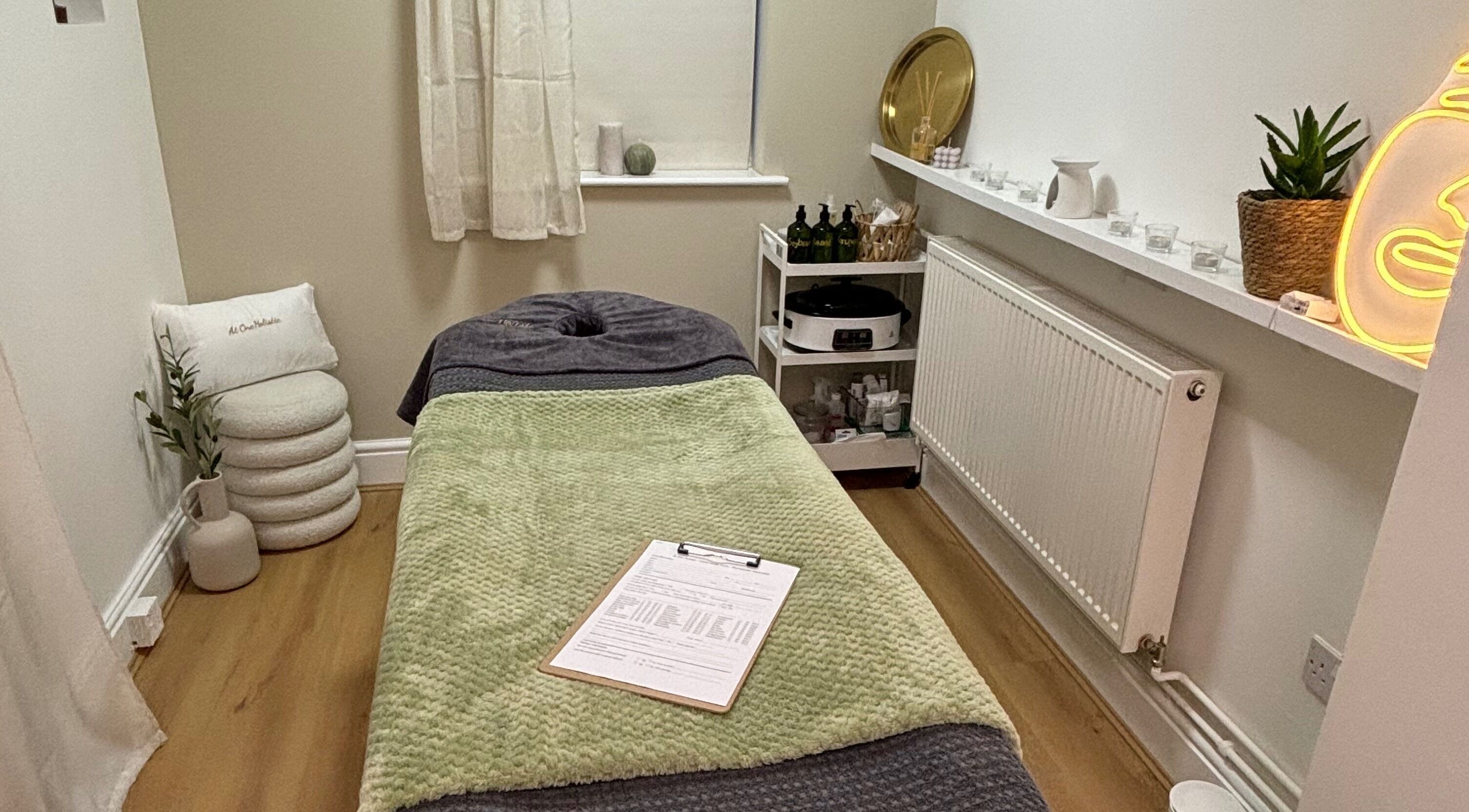 Calming treatment room at At One Holistic Wellbeing, Halesowen, England, GB, featuring a massage bed and decor.