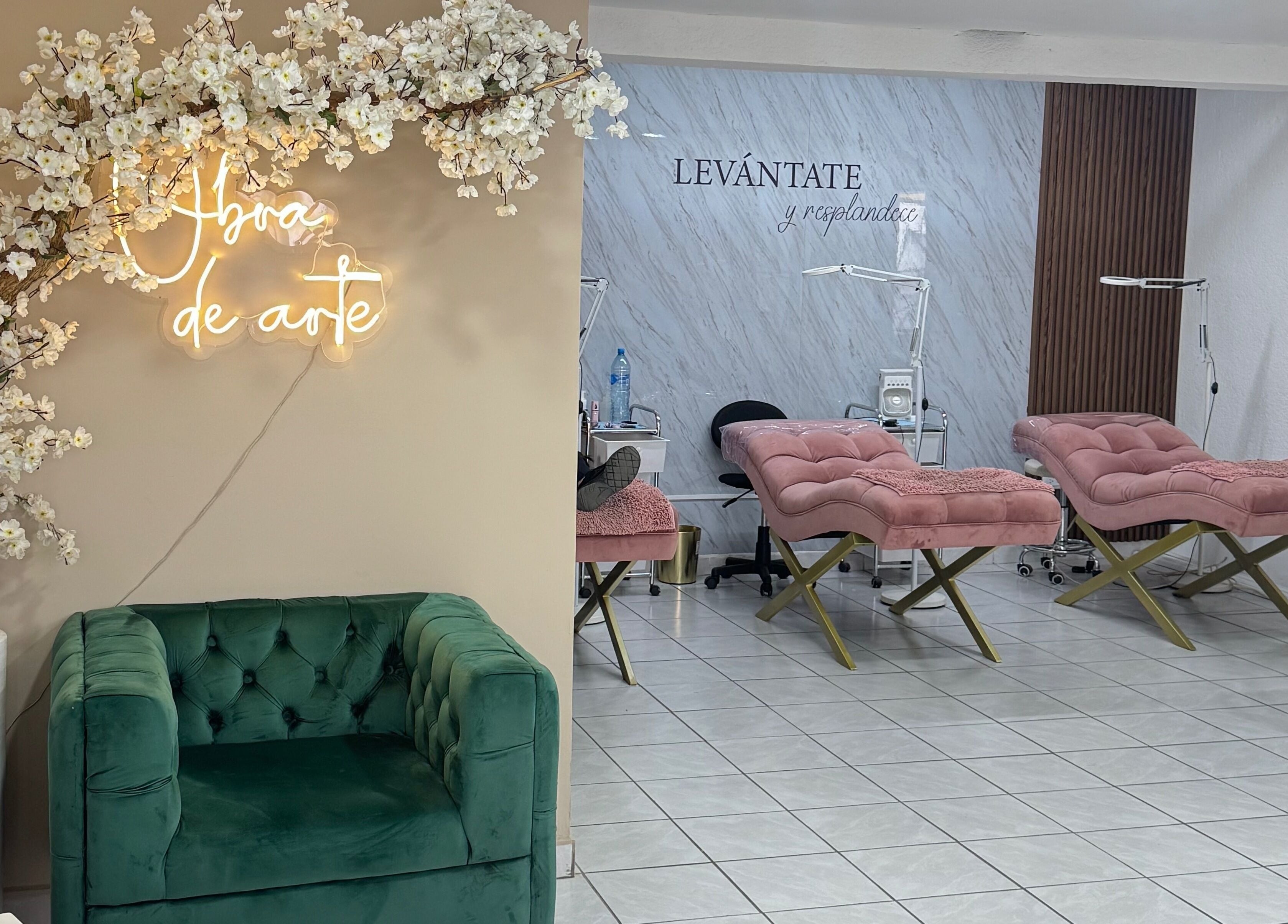 Interior elegante de Marana Studio en San Luis Potosí, MX, con sofás verdes y florecientes blancas.