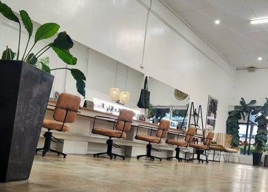 Elegant interior of Suede Hair Skin Body in Cairns City, Queensland, AU, showcasing stylish salon chairs and greenery.